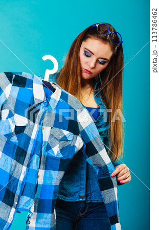 Fashionable woman trying plaid shirt Fashionable woman trying plaid shirt 113786462
