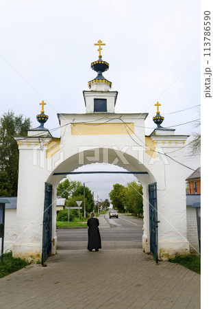 A priest looks at the street from the courtyard of the church in the town of Tutaev 113786590
