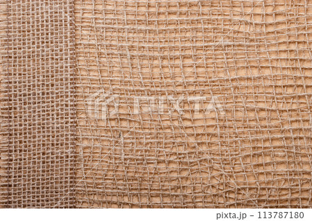 Jute ribbon on burlap cloth background Jute ribbon on burlap cloth background 113787180