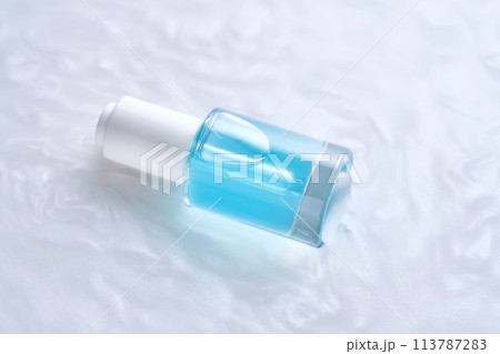 Bottles of serum with a dropper in liquid with pearl tints. 113787283