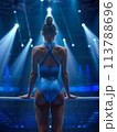 Focused on her balance beam routine, the female gymnast excels under the spotlight of the gym lights 113788696