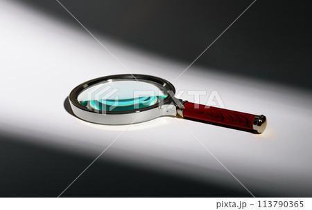 Vintage magnifying glass on shadow background. Minimal retro object, old glass lens. Search, zoom, 113790365