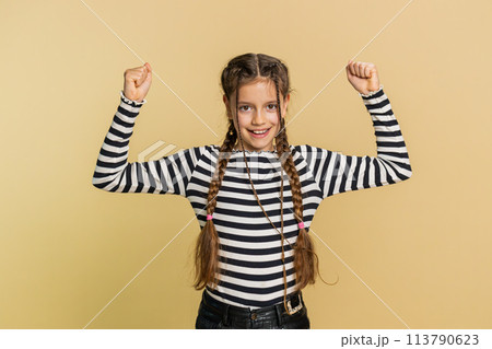 Fit sporty child girl kid showing biceps and looking healthy, feeling power strength success win 113790623