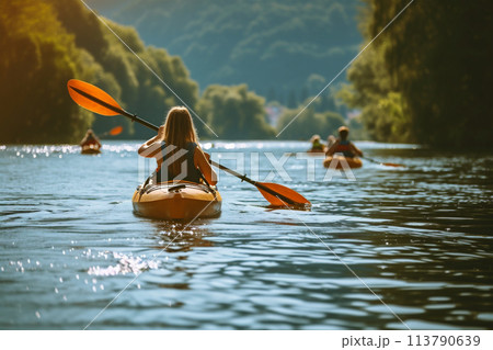 Rear view of woman paddles her kayak 113790639
