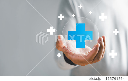 A hand grasps plus icon for medical care, signifying advantages. Health insurance health concept featuring access to welfare health and unoccupied space. 113791264