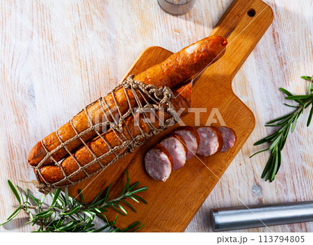 Sliced half-smoked sausages on wooden table Sliced half-smoked sausages on wooden table 113794805