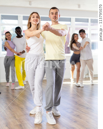 Young man and woman practicing waltz dance in pair in training hall Young man and woman practicing waltz dance in pair in training hall 113795070