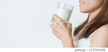 Milk drink and Daily Routine concept. Young woman Drinking milk with high calcium and nutrition at home, woman holding soy milk on glass with protein. Healthy, wellness and happy lifestyle Milk drink and Daily Routine concept. Young woman Drinking milk with high calcium and nutrition at home, woman holding soy milk on glass with protein. Healthy, wellness and happy lifestyle 113797200