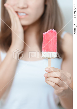 Teeth Sensitive to Cold concept. woman hold Ice cream and having toothache and pain after eat. Tooth Decay or Gum Disease, Grinding Teeth and Stress, Exposed Nerve Roots, Crack and Receding Gums 113797236