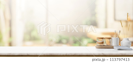 A tabletop with bath accessories against a blurred background of a contemporary luxurious bathroom. 113797413