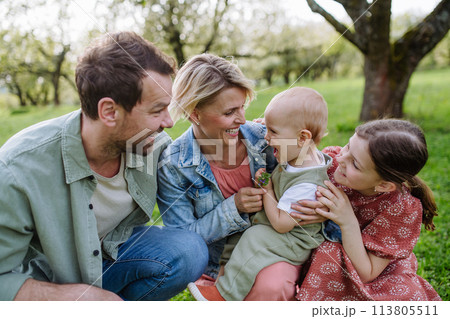 Family portrait with daughter and small toddler, baby, outdoors in spring nature. Family portrait with daughter and small toddler, baby, outdoors in spring nature. 113805511
