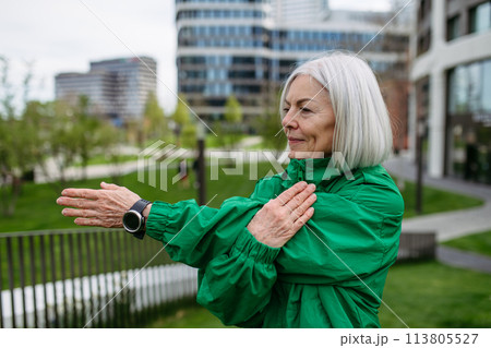Mature woman stretching before run. Exercising after work for good mental health, physical health, relieving stress and boost mood. 113805527