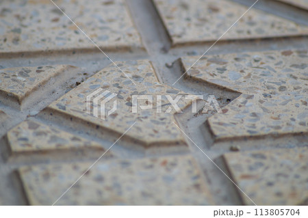 Embossed surface with carved edges of granite figured decorative tiles. Designer design of the street sidewalk 113805704