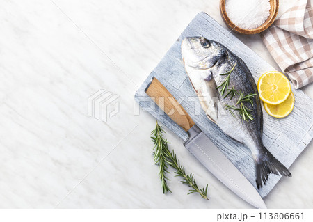 Fresh sea bream fish on cutting board on kitchen table. Top view. 113806661
