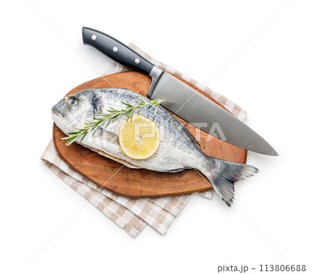 Fresh sea bream fish, rosemary and lemon on cutting board isolated on white background. 113806688