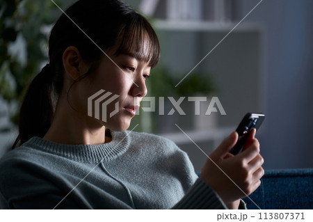 スマートフォンを見て落ち込む女性 スマートフォンを見て落ち込む女性 113807371