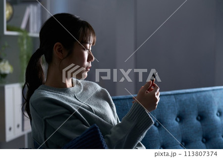 スマートフォンを見て落ち込む女性 113807374