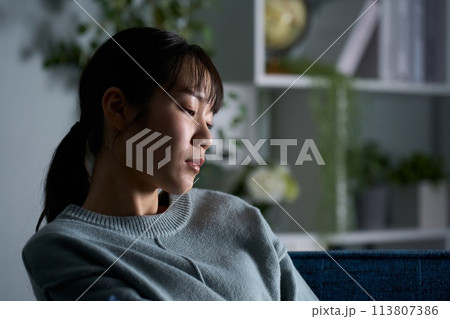 暗い部屋で考え事をする女性 暗い部屋で考え事をする女性 113807386