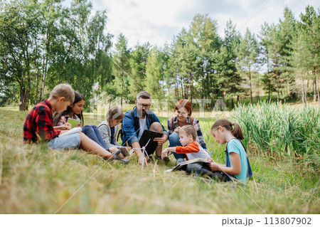 Students learning about renewable wind energy during field teaching class. Outdoor active education helping young student to learn about ecology and sustainability. 113807902