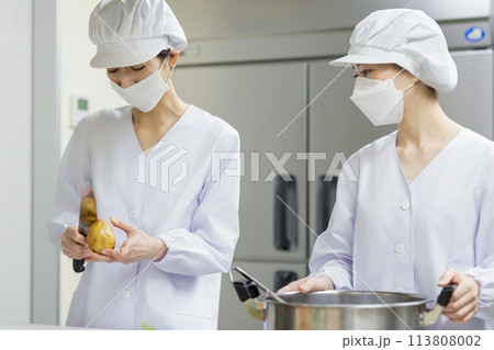 白衣を着て食事を作る女性 113808002