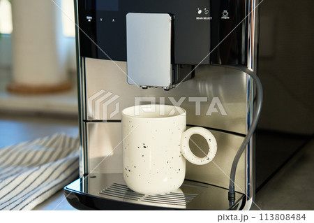 Coffee machine with cup of coffee in kitchen 113808484