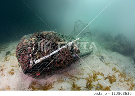 Abandoned fishing net and plastic garbage in the sea 113808630
