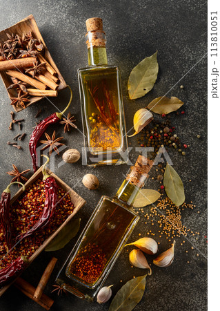 Bottles of olive oil and various spices on a kitchen table. Bottles of olive oil and various spices on a kitchen table. 113810051