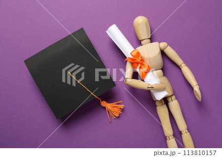 Wooden statuette of a man with a graduation hat and diploma. 113810157