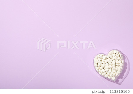 Hormonal pills for the heart, on a purple background. 113810160