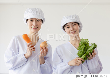 白衣を着て食事を作る女性 113810245