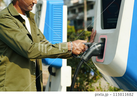 Cropped image of driver using public charging point 113811682