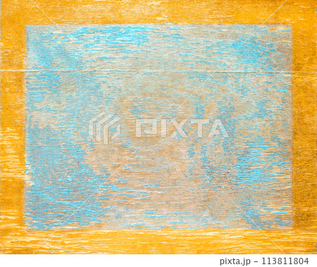 Worn blue paint on old wood plank with gold edge frame. Shabby plank with cracks and stains. Copy space 113811804