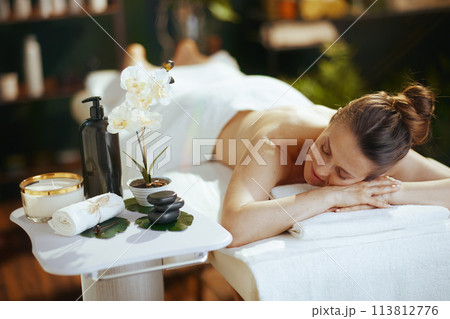 relaxed 40 years old woman in spa salon laying on massage table relaxed 40 years old woman in spa salon laying on massage table 113812776