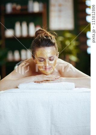 relaxed modern woman in massage cabinet laying on massage table relaxed modern woman in massage cabinet laying on massage table 113812806