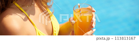 Header with woman drinking fruit cocktail by swimming pool 113813167