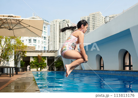 Mid-air image of girl jumping in swimming pool 113813176