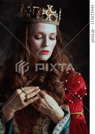 medieval queen in red dress with white makeup and crown 113813445