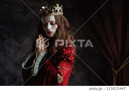 medieval queen in red dress with crown praying medieval queen in red dress with crown praying 113813447