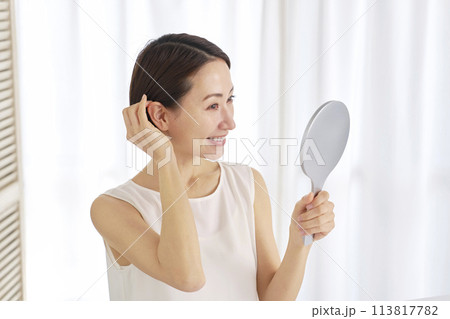 髪の毛で顔を見る中年女性 髪の毛で顔を見る中年女性 113817782