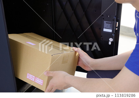 宅配ボックスに荷物を入れる配達員 113819286