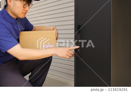 宅配ボックスに荷物を入れる配達員 宅配ボックスに荷物を入れる配達員 113819291