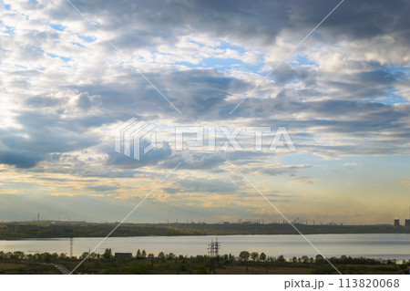 Beautiful cloudy scenery over the lake and the city at sunset at dusk 113820068
