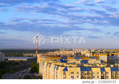 Top view of the city in the light of the sun under a cloudy sky at sunset 113820133