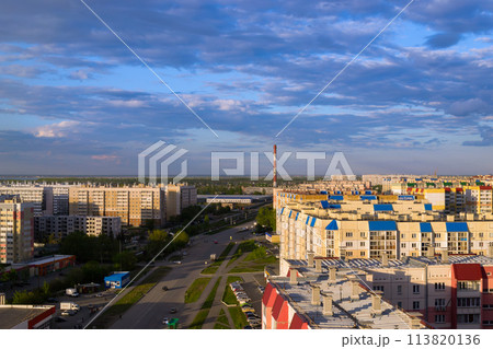 Top view of the city in the light of the sun under a cloudy sky at sunset 113820136