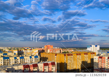 Top view of the city in the light of the sun under a cloudy sky at sunset 113820159