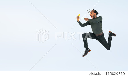 スマホを見ながらジャンプする黒人男性の全身写真 113820750