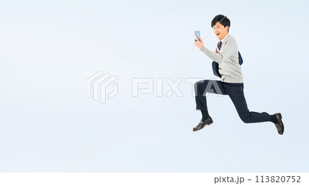 スマホを見ながらジャンプする制服を着た男子学生の全身写真 スマホを見ながらジャンプする制服を着た男子学生の全身写真 113820752