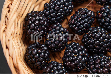 Fresh organic blackberries in a rustic rattan wicker bowl. Juicy black berry close up 113821687