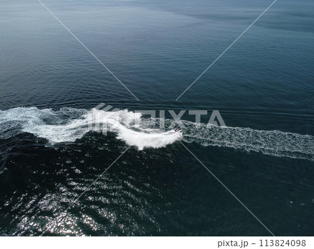 People are playing a jet ski in the sea, leaving abstract white footprints on the water. Aerial top view. Amazing nature background. Water color are beautifully vibrant. Fresh freedom. Adventure day. 113824098