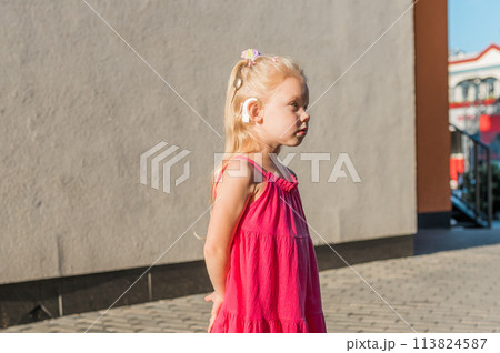Child girl walks and have fun outdoor with cochlear implant on the head. Hearing aid and treatment concept. Copy space. Inclusion and people with disability Child girl walks and have fun outdoor with cochlear implant on the head. Hearing aid and treatment concept. Copy space. Inclusion and people with disability 113824587